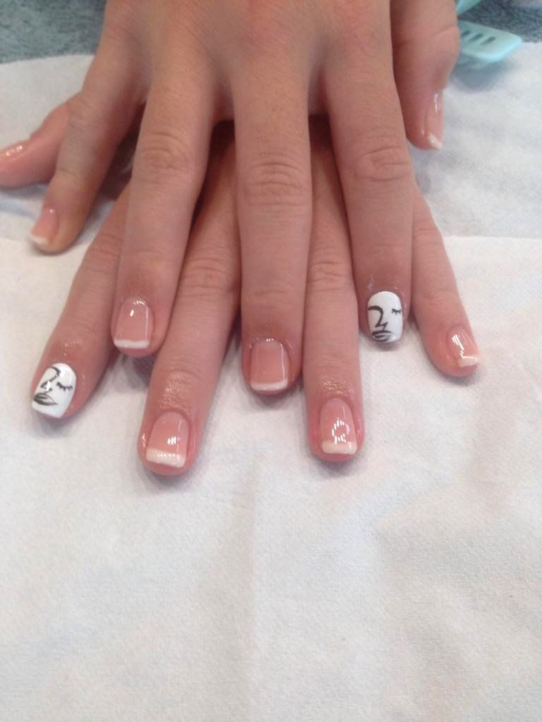 A close up of a woman 's nails with a face on them