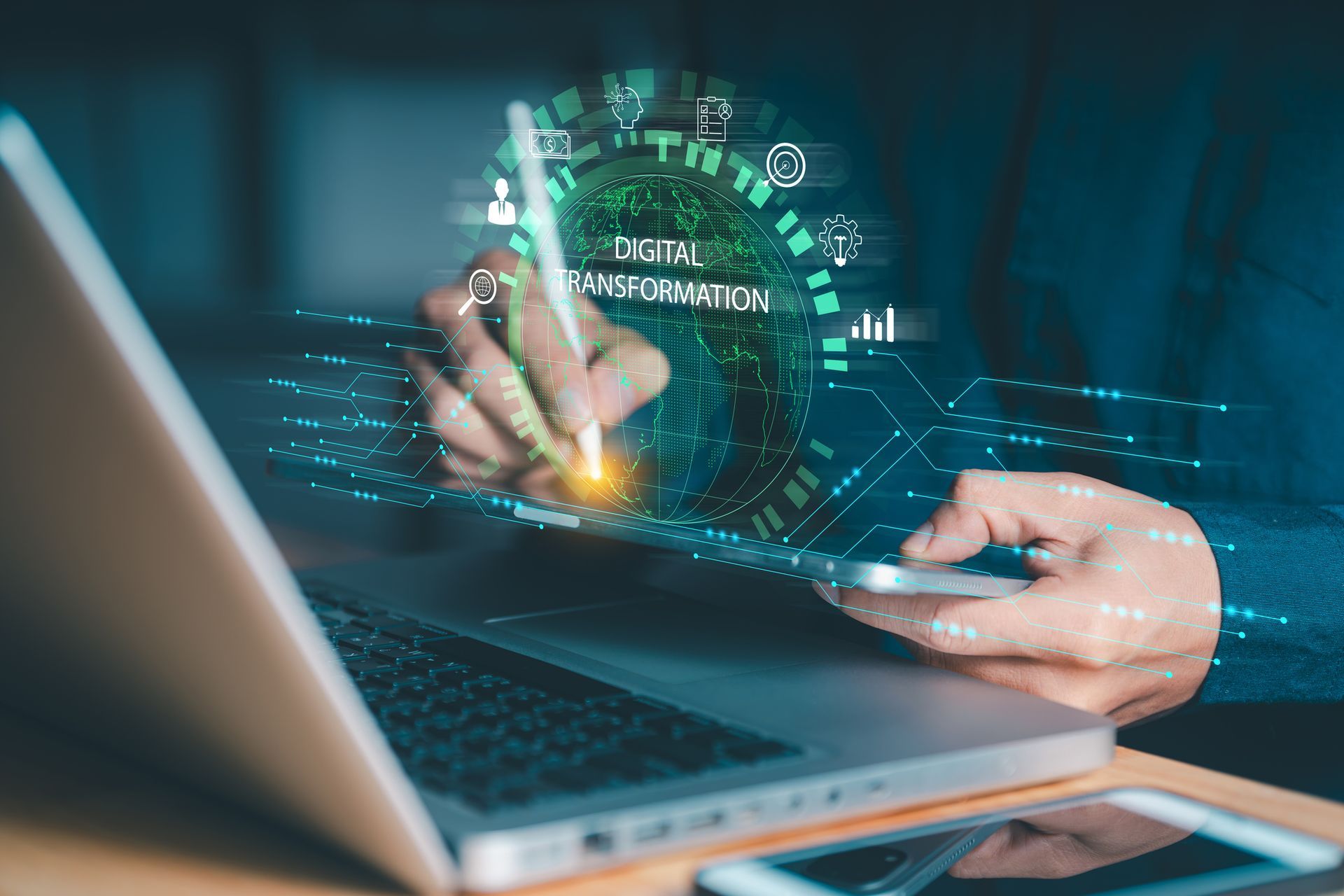 A person uses a stylus on a digital tablet, interacting with a glowing, blue digital interface overlaying a laptop.