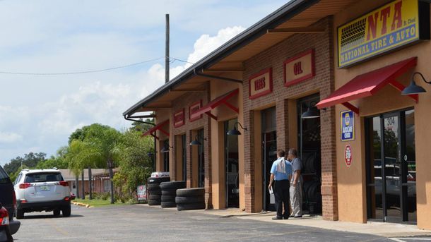 A car is parked in front of a tire shop.