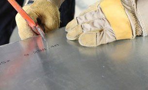 A technician working on sheet steel