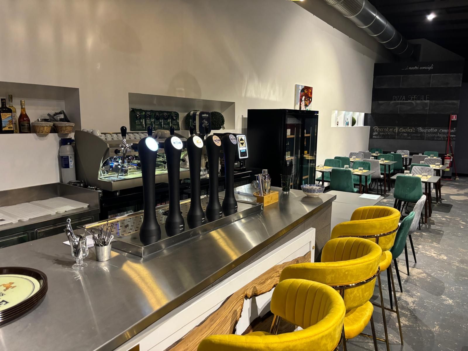 Su un tavolo ci sono quattro pizze e dei bicchieri di vino.