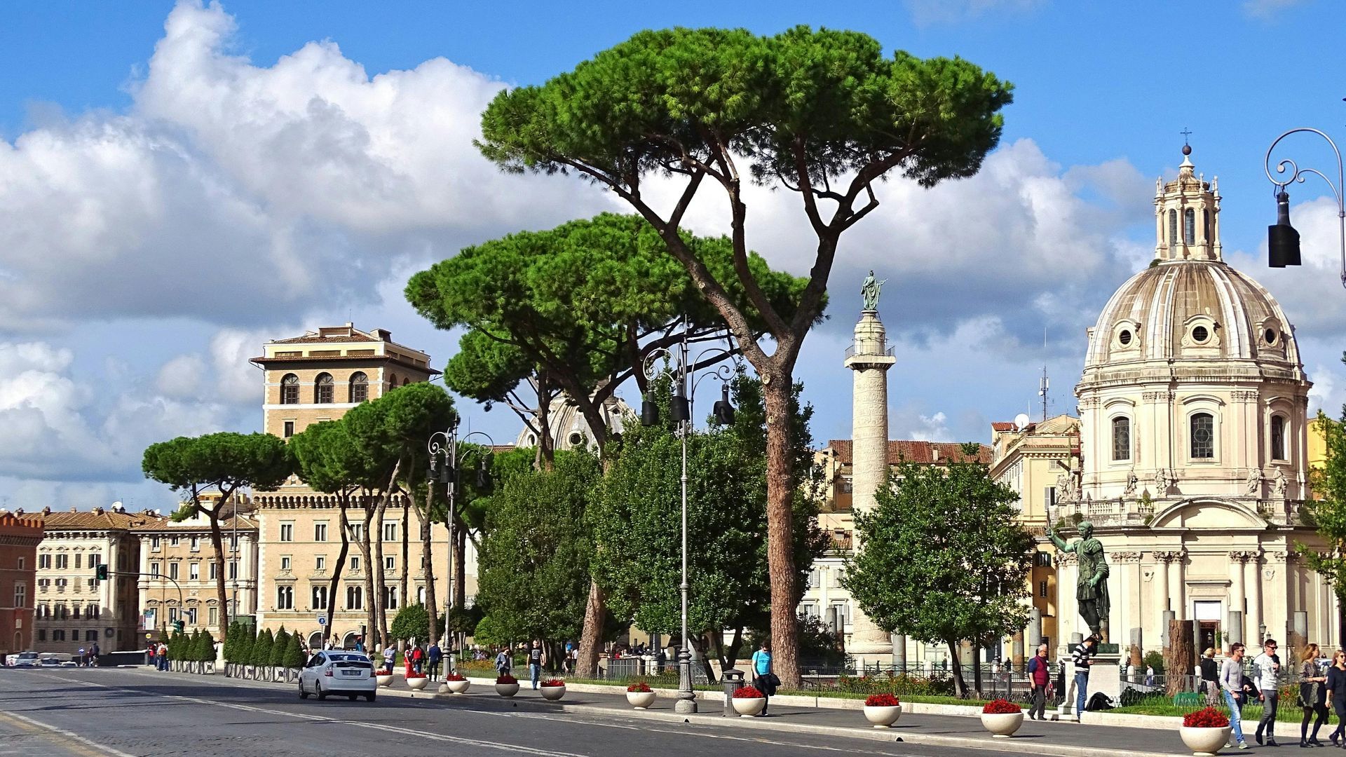 A city street with a dome shaped building in the background