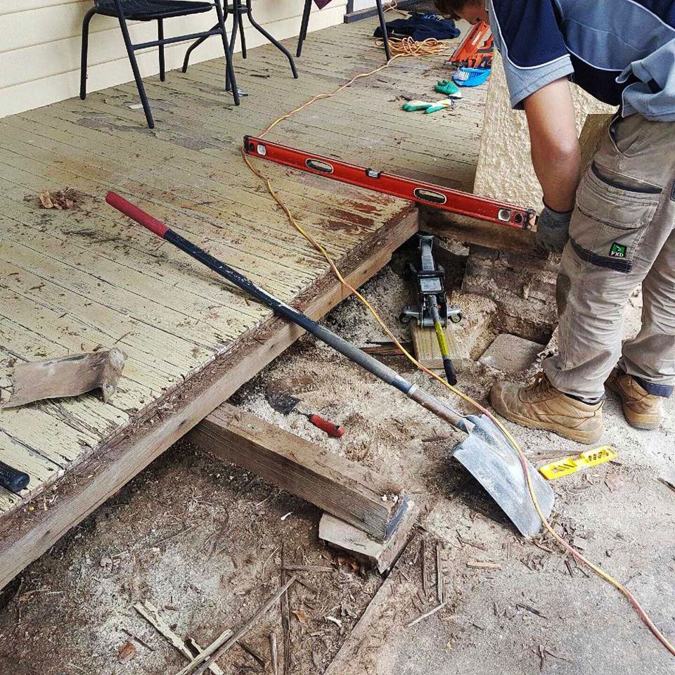 A Man Is Working On A Deck With A Shovel And A Level – Horsham, VIC - ALK Property Maintenance