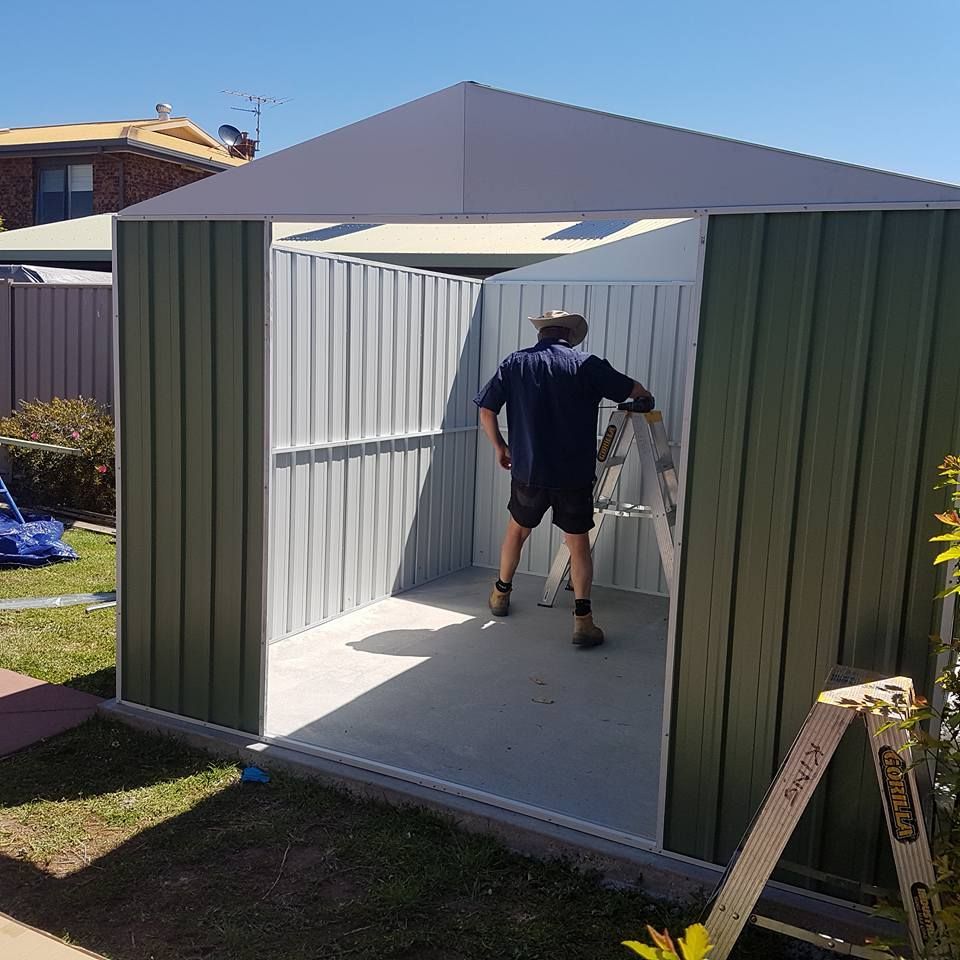 A Man Is Standing Inside Of A Green And White Shed – Horsham, VIC - ALK Property Maintenance