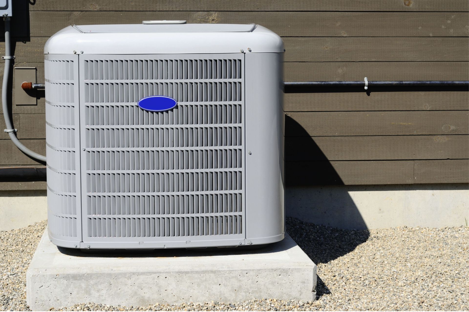 A carrier air conditioner is sitting on a concrete block