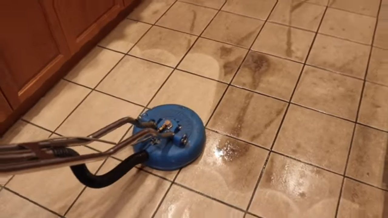 A person is cleaning a tile floor with a machine.