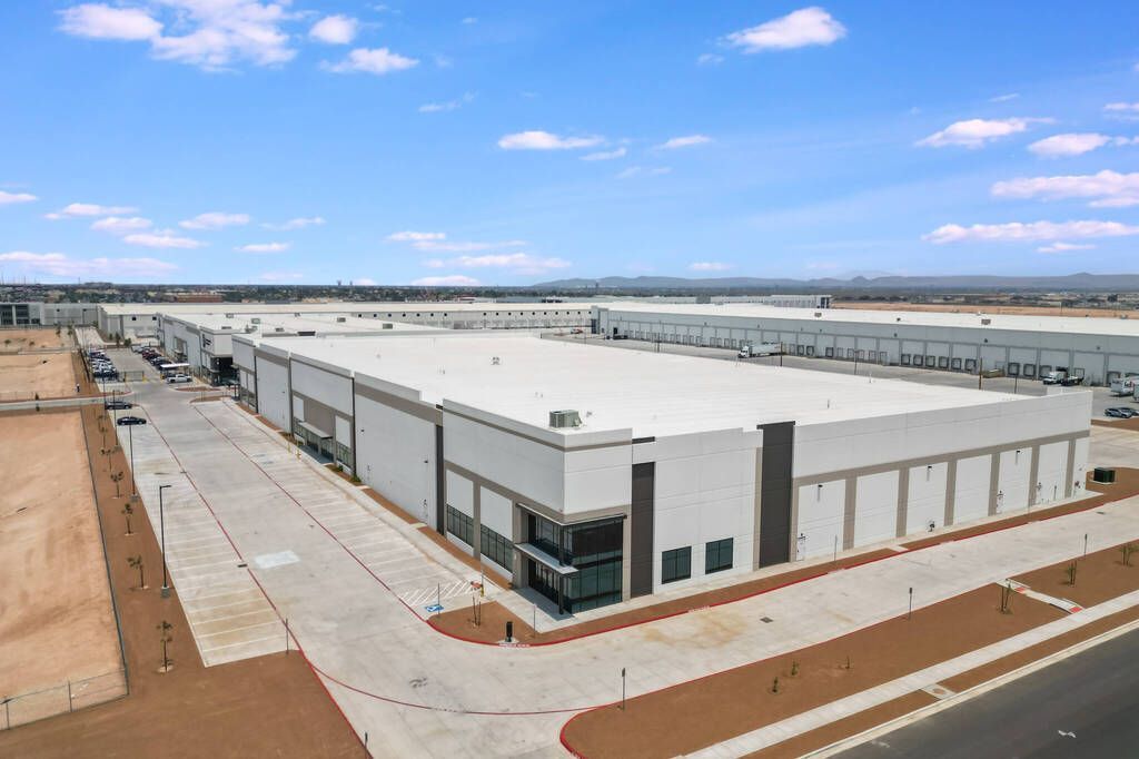 An aerial view of a large warehouse with a white roof.