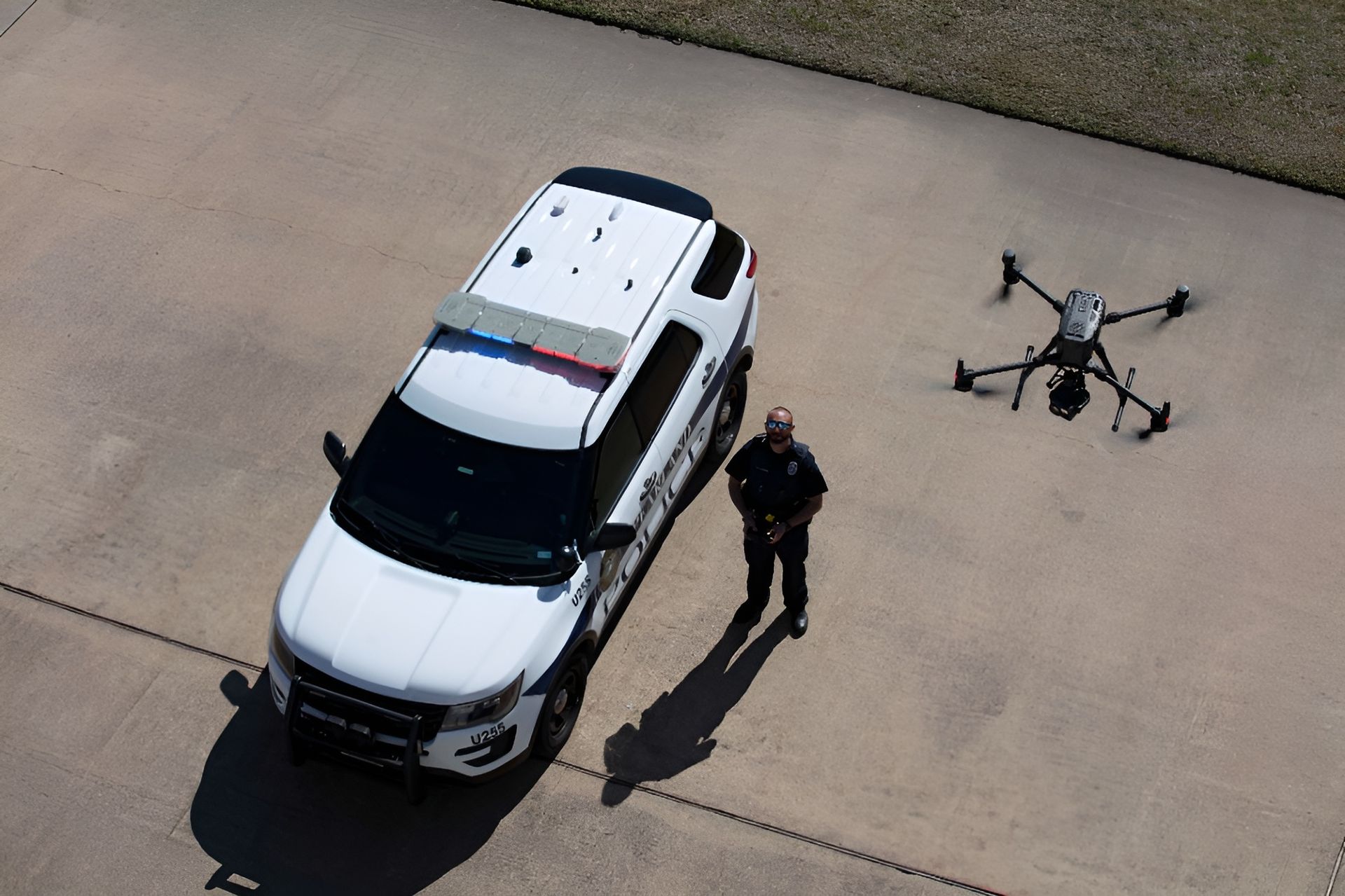 An aerial view of a police car and a drone in a parking lot.