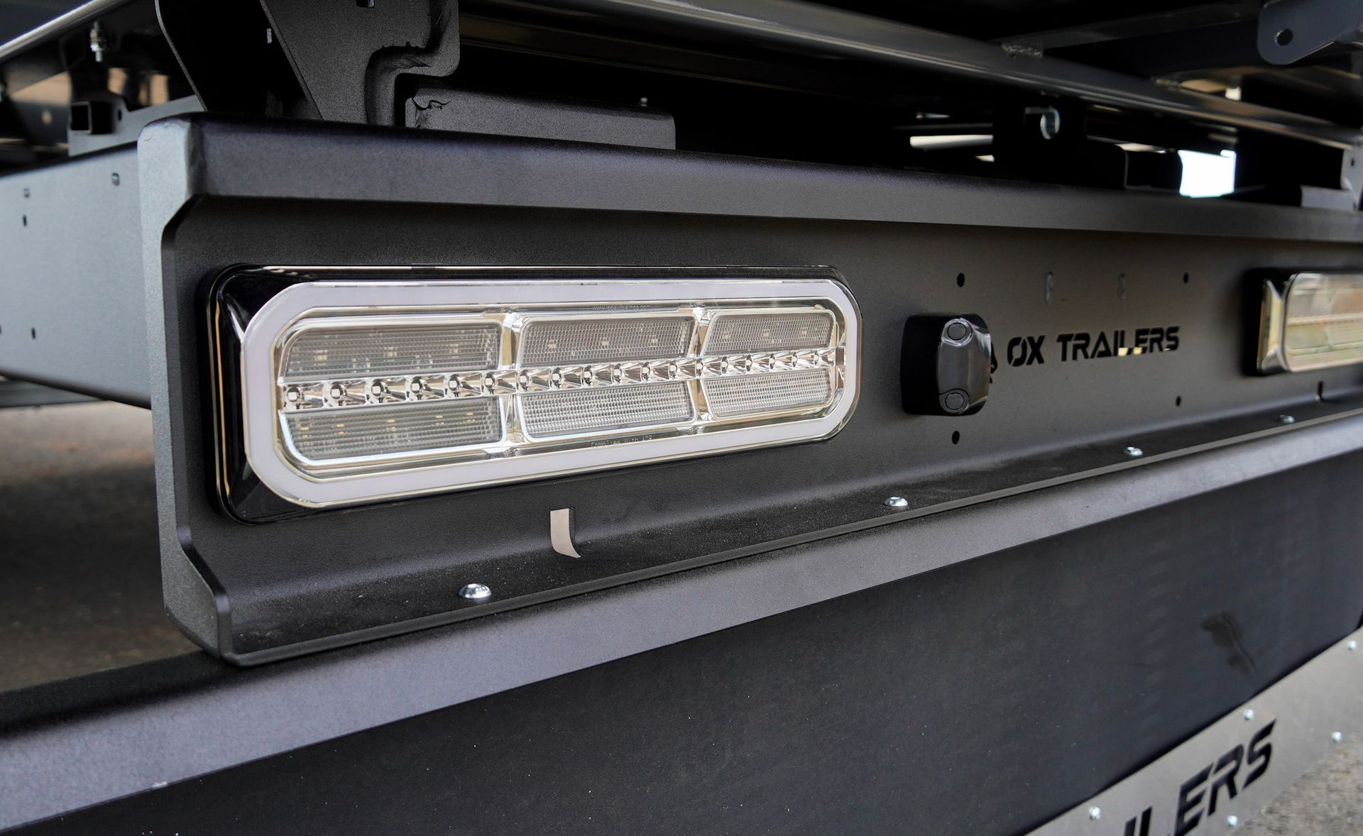 maxilamp taillights with white leds installed onto rear taillight channel of an ox trailer flat top trailer.