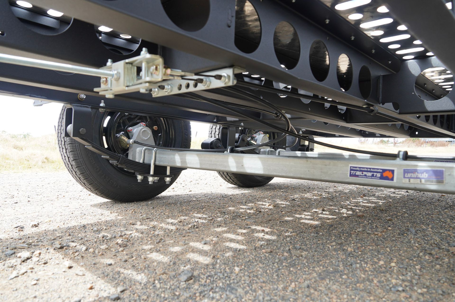 The underneath of a plant trailer, showing the load sharing suspension and drop axle attached to the wheel. 