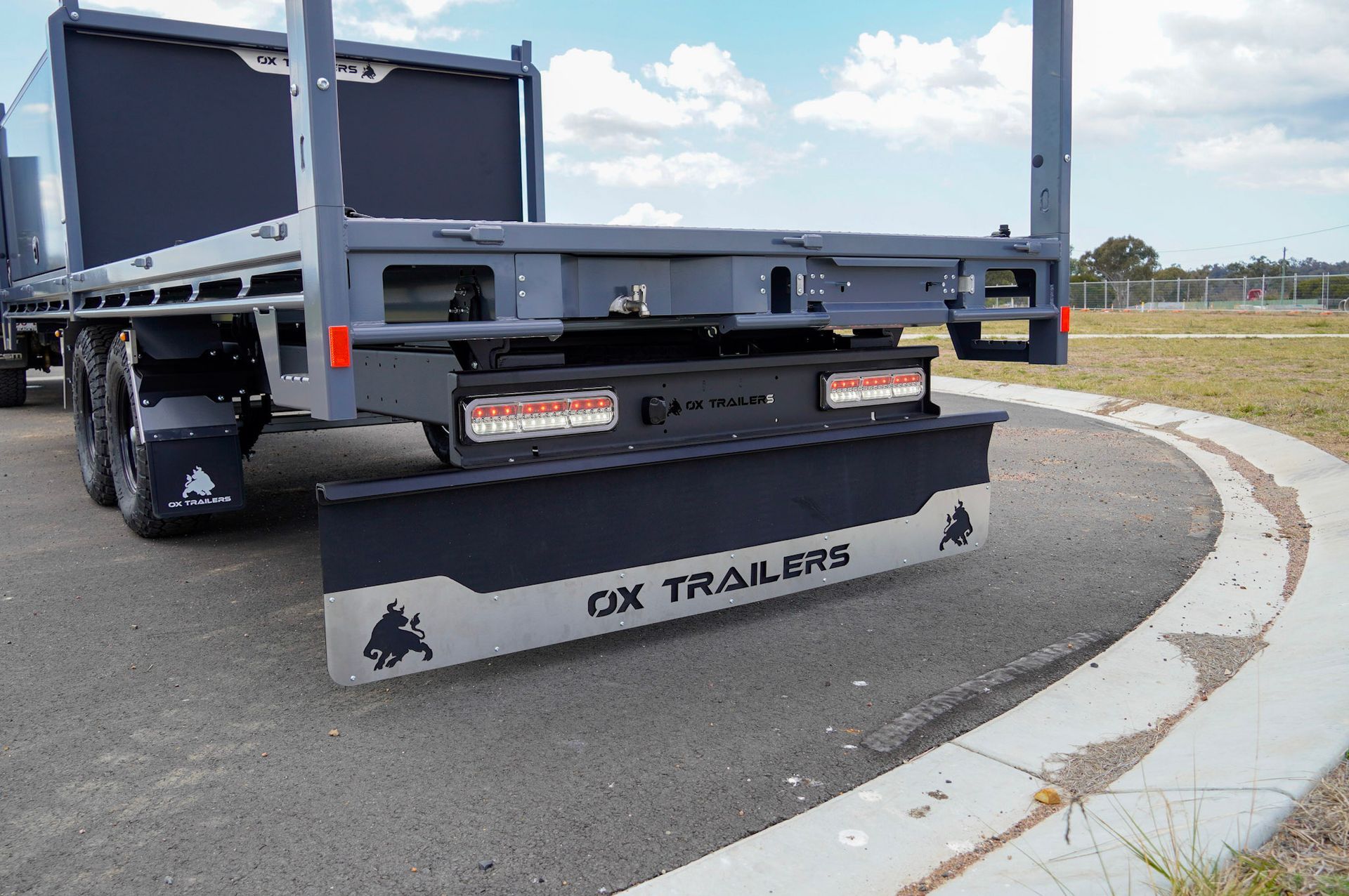 custom full-width mud flap on the rear of an ox trailers flat top trailer.