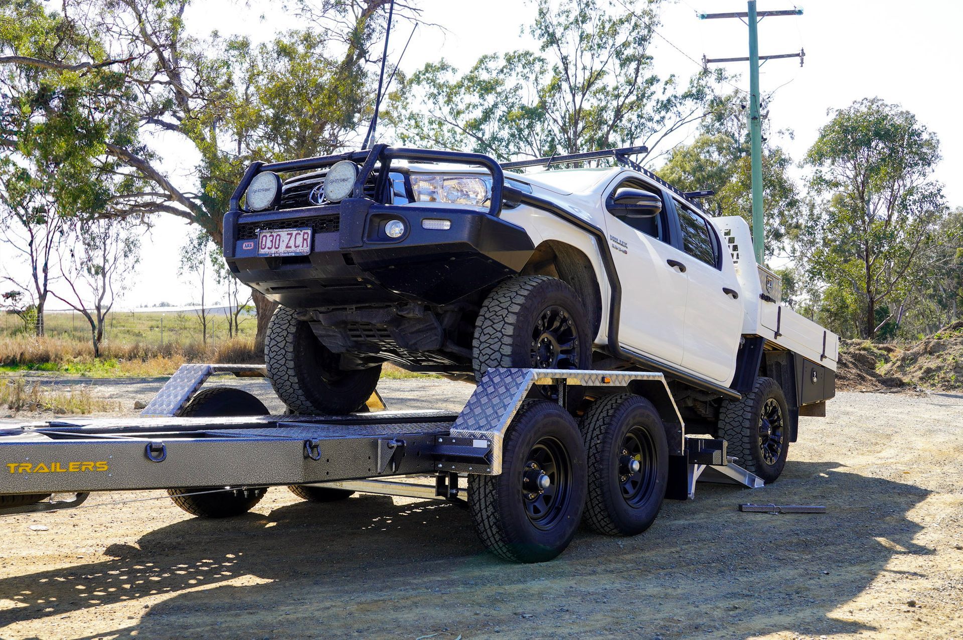 DMC Plumbings Plant Trailer being driven onto by a Hilux ute.