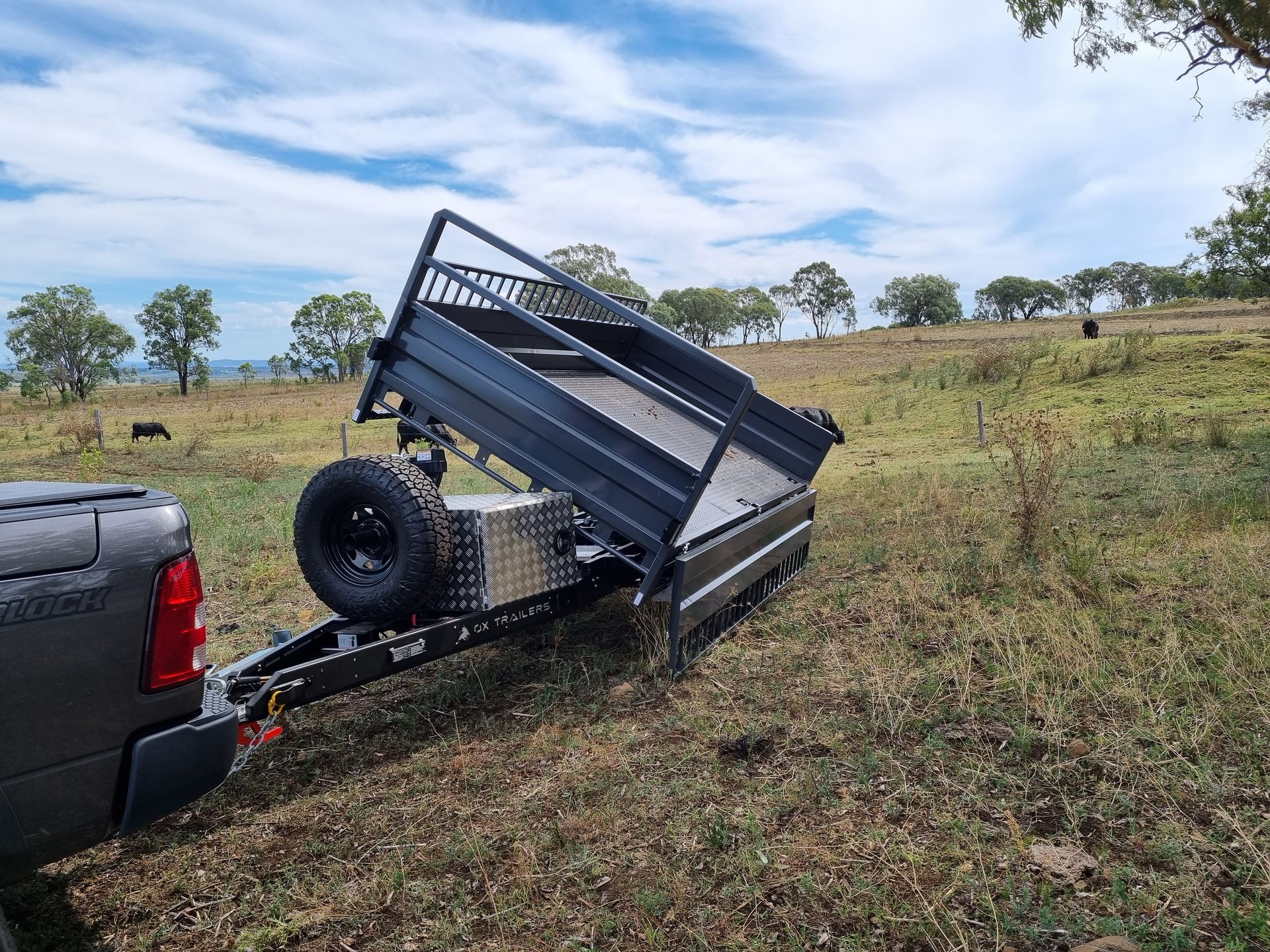 A 3-way tipper at rural farm, the trailer has tipped to the side with the dropsides down.