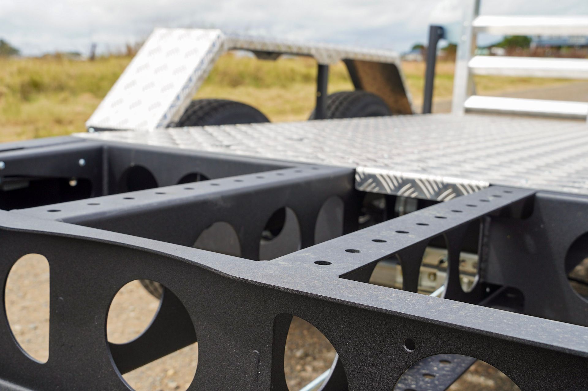 A close up of the wheel placement of the plant trailer, showing the ability to move the placement forward or backward.