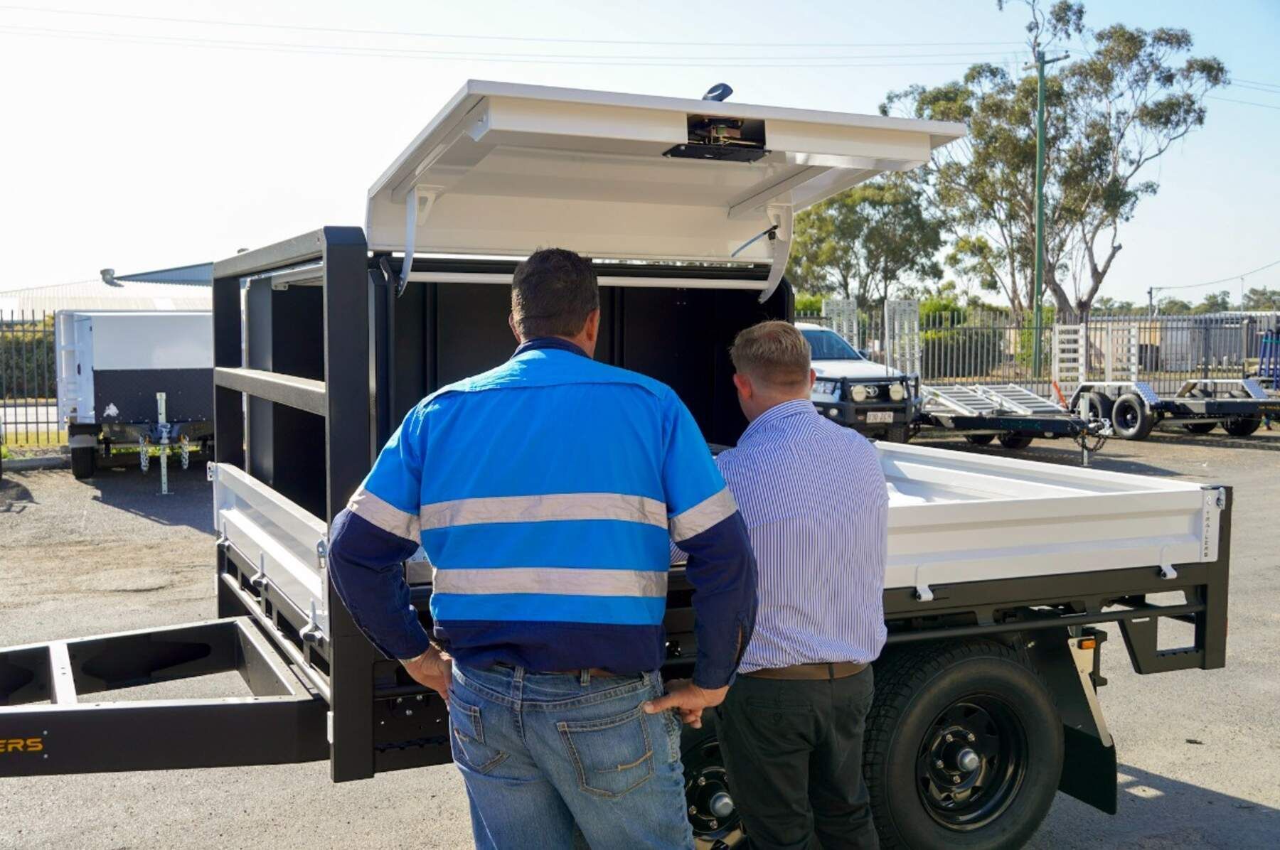6m long flat top trailer built custom by ox trailers with ladder racks, lift-off canopy and rear drawer at rural queenslad construction site.
