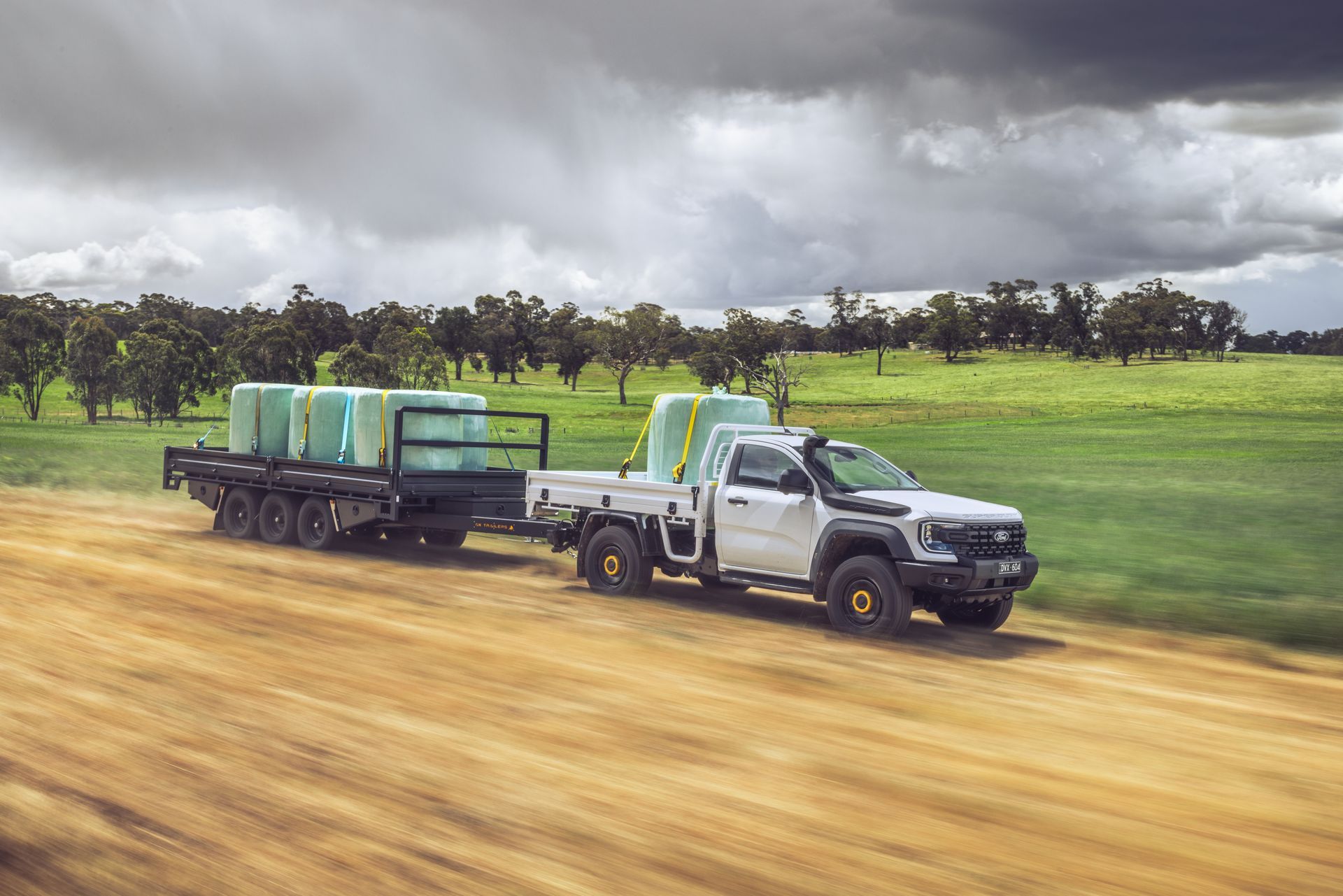 three flat top trailers by a country dam.