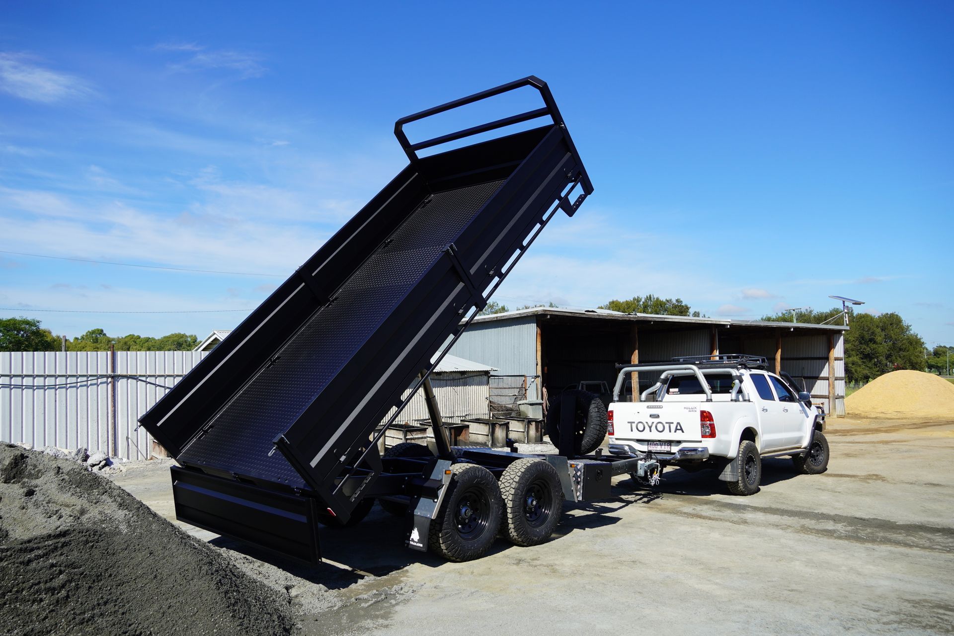 The king of spades rear tipper trailer at full tilt at a sand quarry.