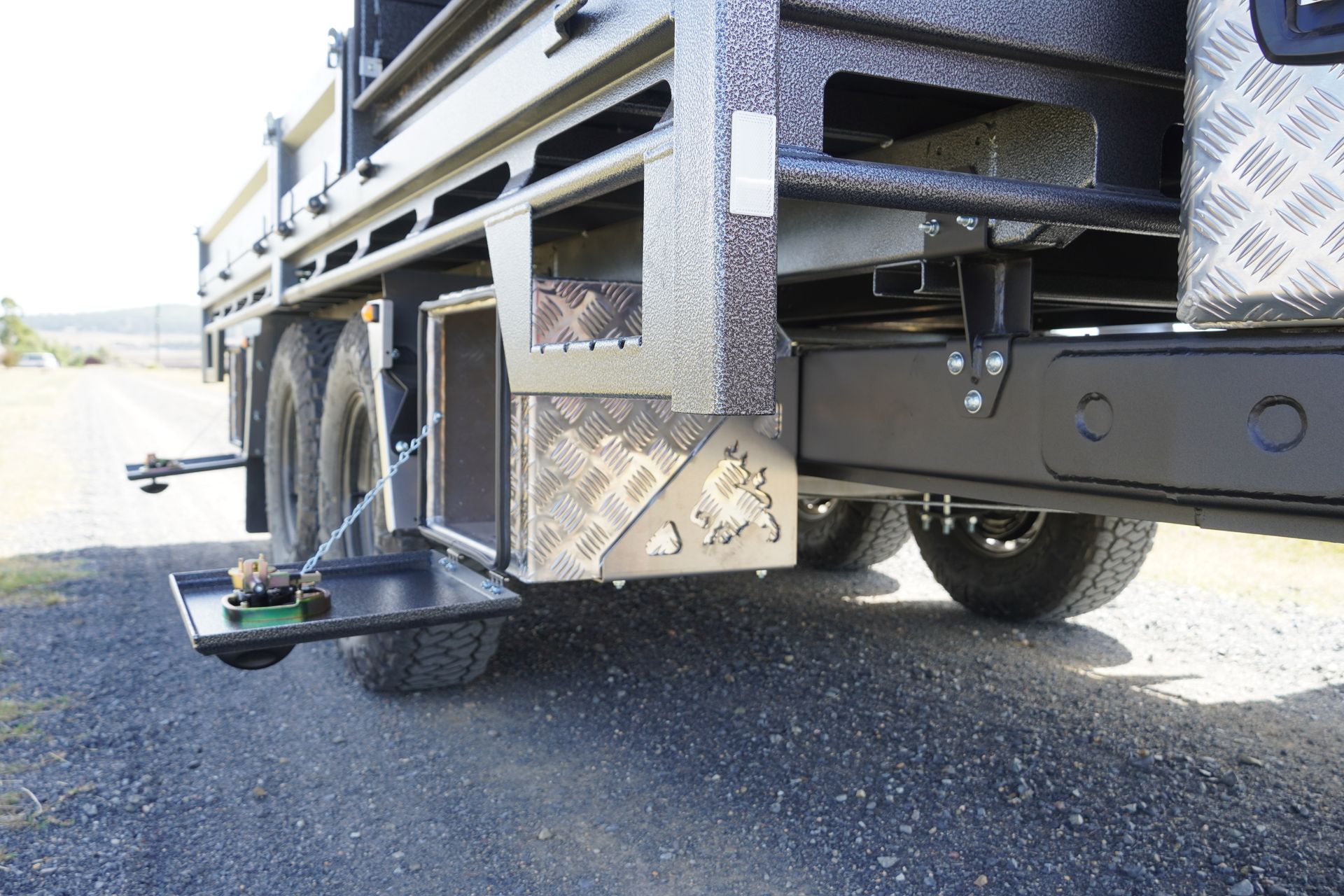 One of the four underbody toolboxes of Tom Clarkes trailer, the toolbox is open, with it's side door suspended by a chain.