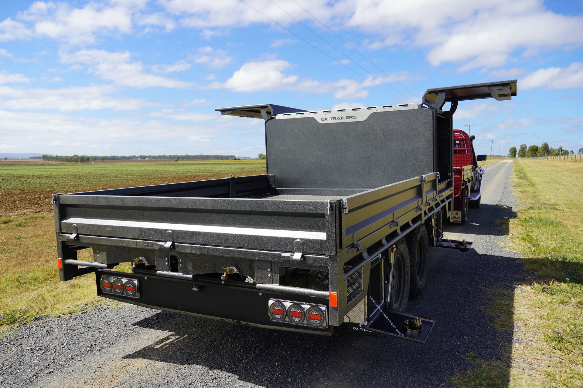 Back view of Tom Clarke's flat top trailer with drop sides up, canopy doors open, showcasing the Aztec Silver color upgrade.
