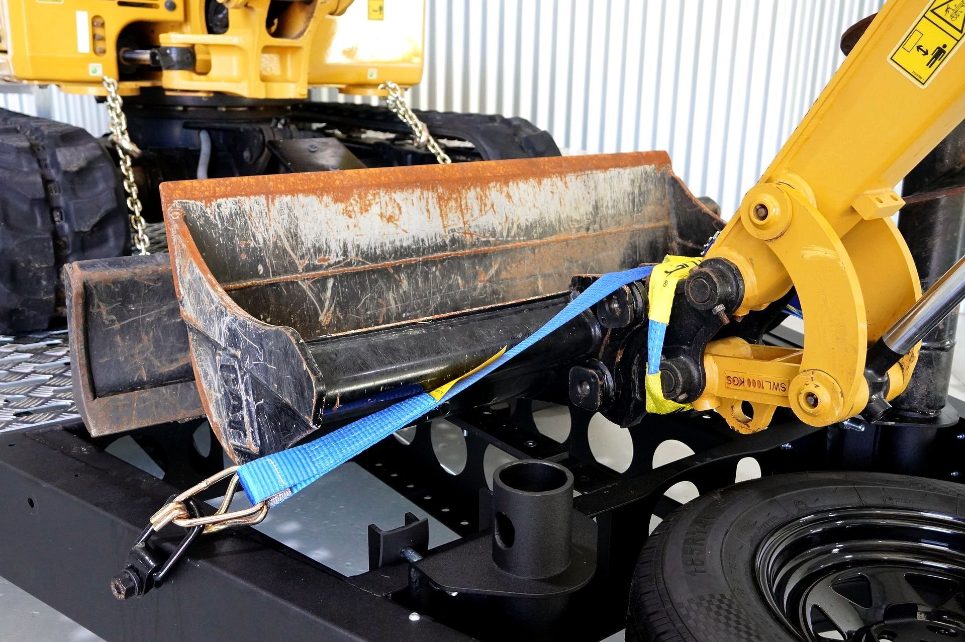 Heavy Duty Plant Trailer with tie down points. Featuring ratchet straps, hooks and tire of excavator.