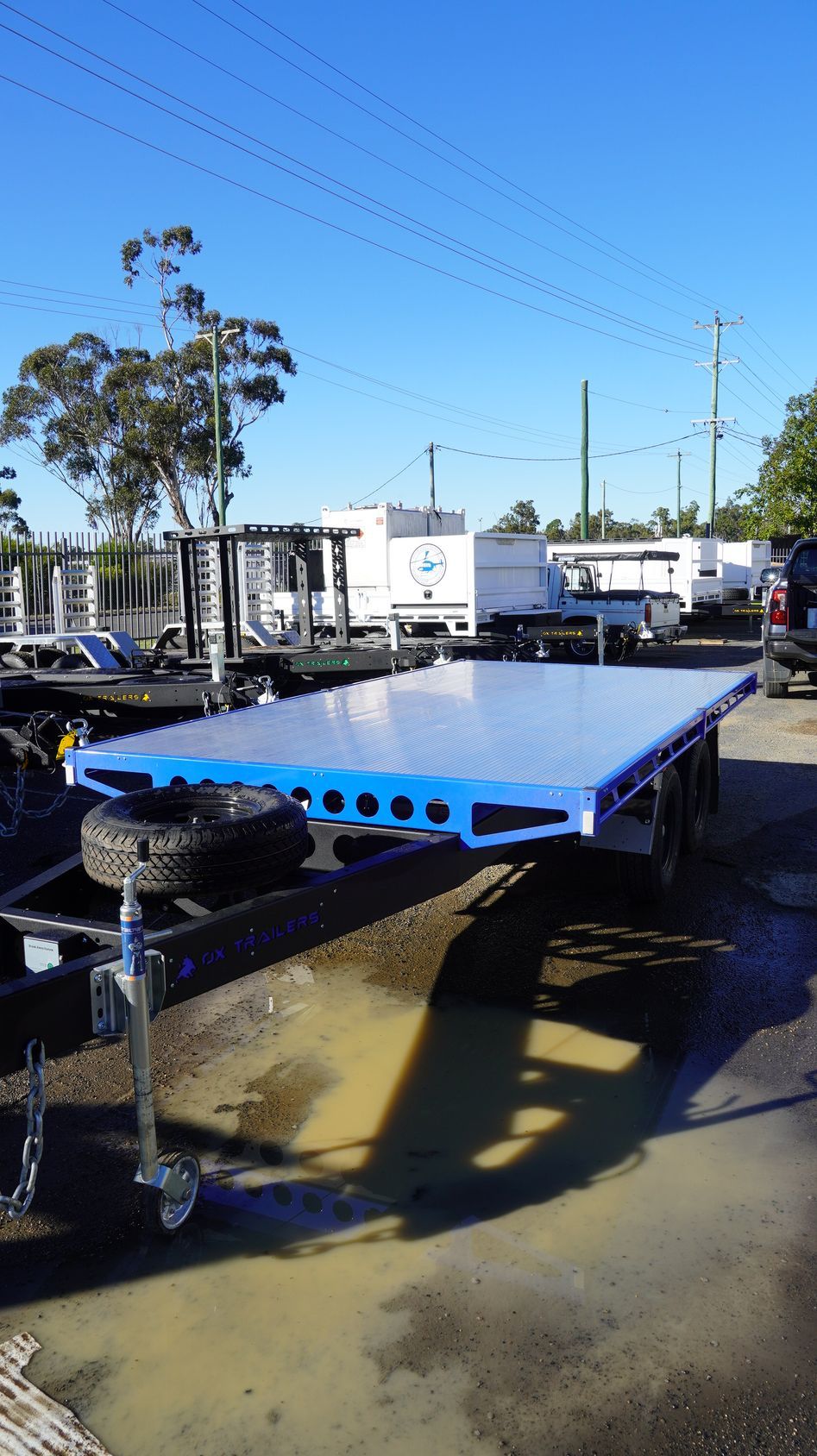 the aluminium extrusion decking of an ox trade series flat top trailer also showing spare wheel holder and jockey wheel.