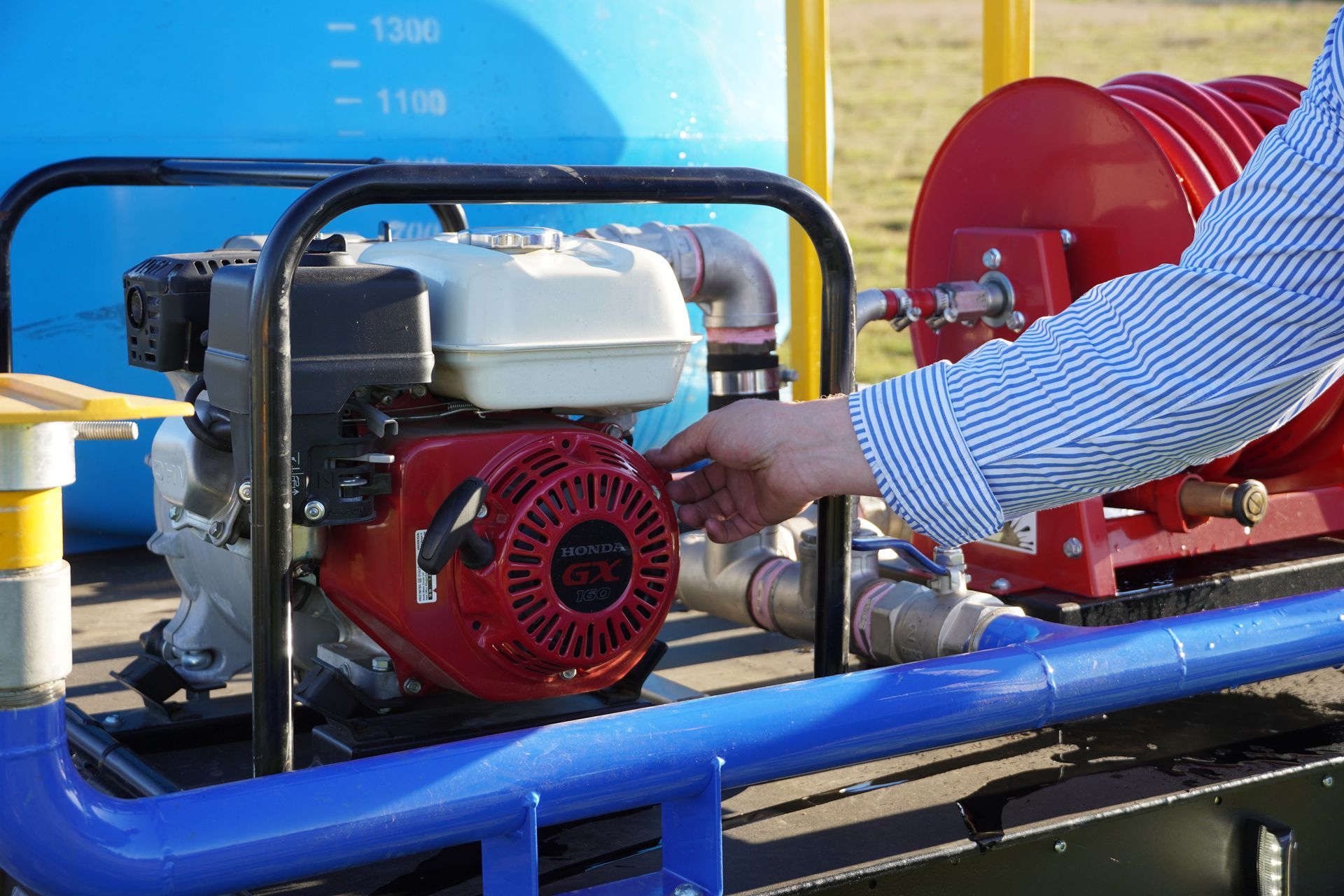 Plant trailer at farm with excavator attachment resting on drawbar. Ox Trailer branding is shown.