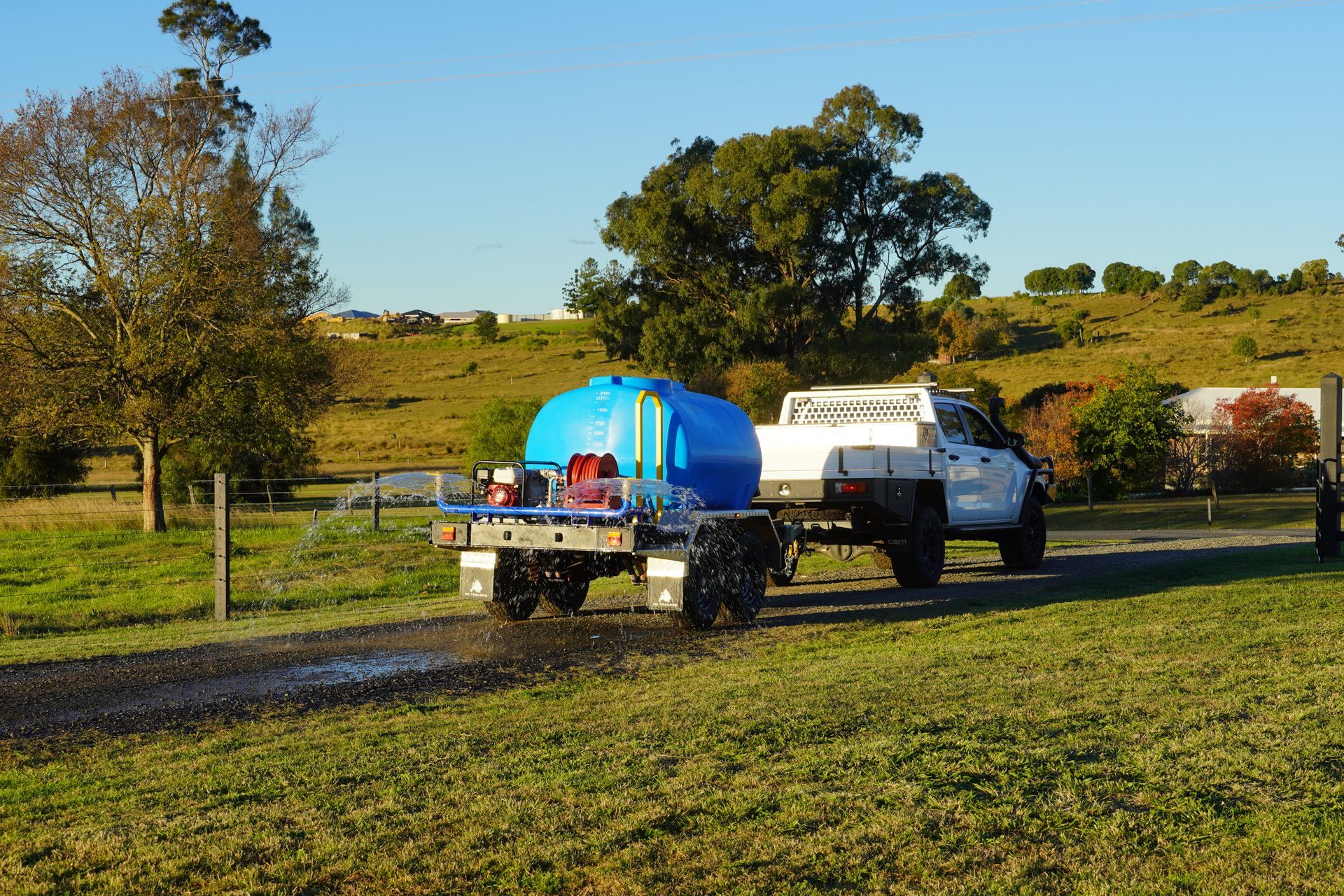 An Ox Water Trailer being used for dust suppression on dirt road.