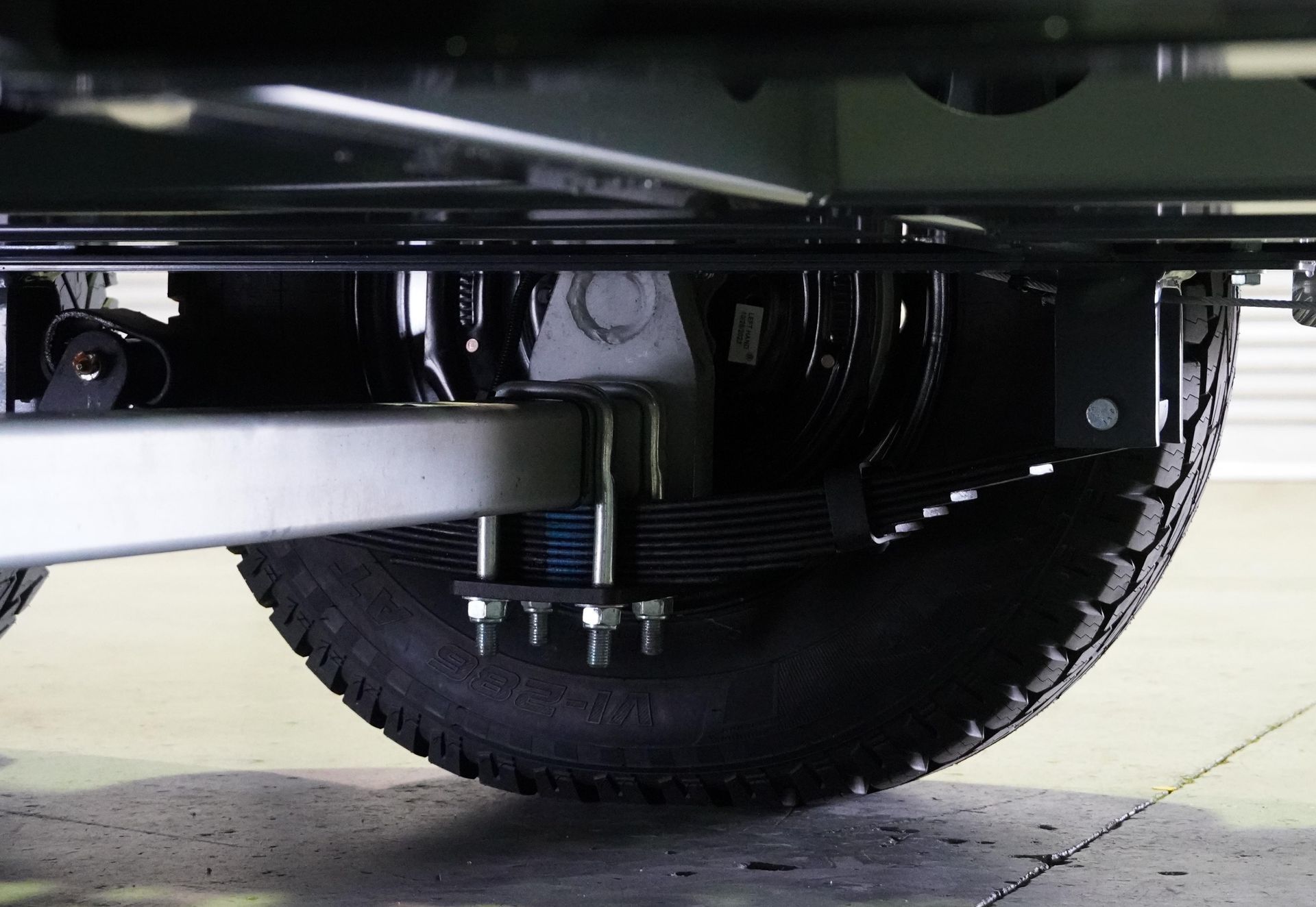 The underneath of a plant trailer, showing the load sharing suspension and drop axle attached to the wheel. 