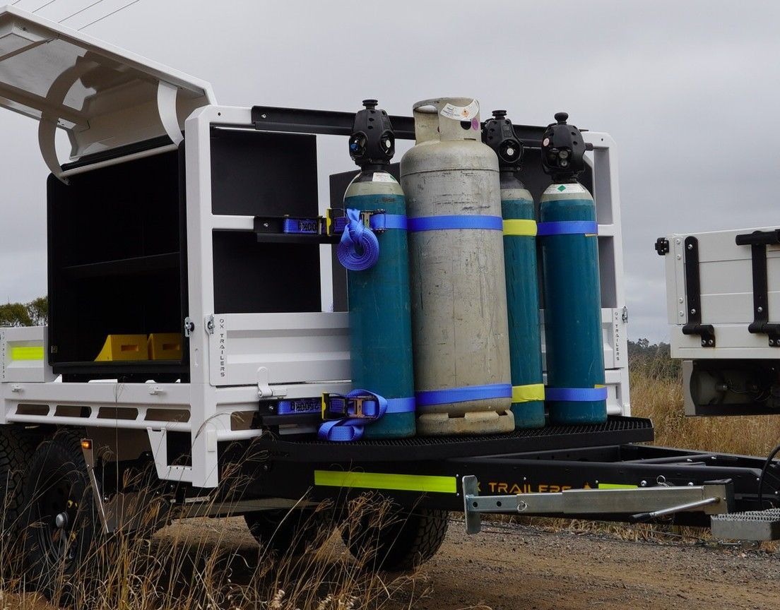 Drawbar-mounted gas bottle frame on an ox trailer.