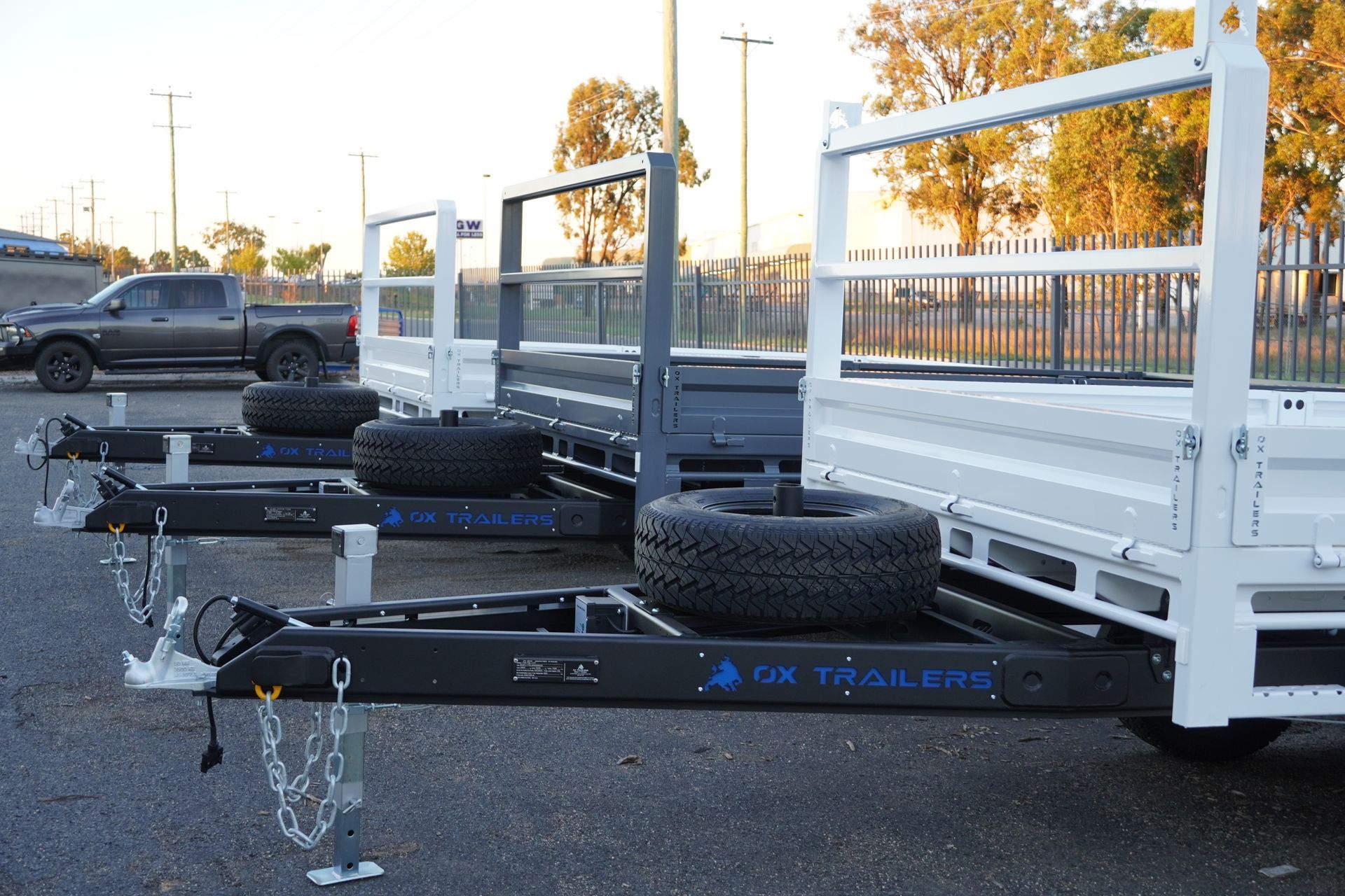 three tipper trailers in a parking lot, all with headboards.