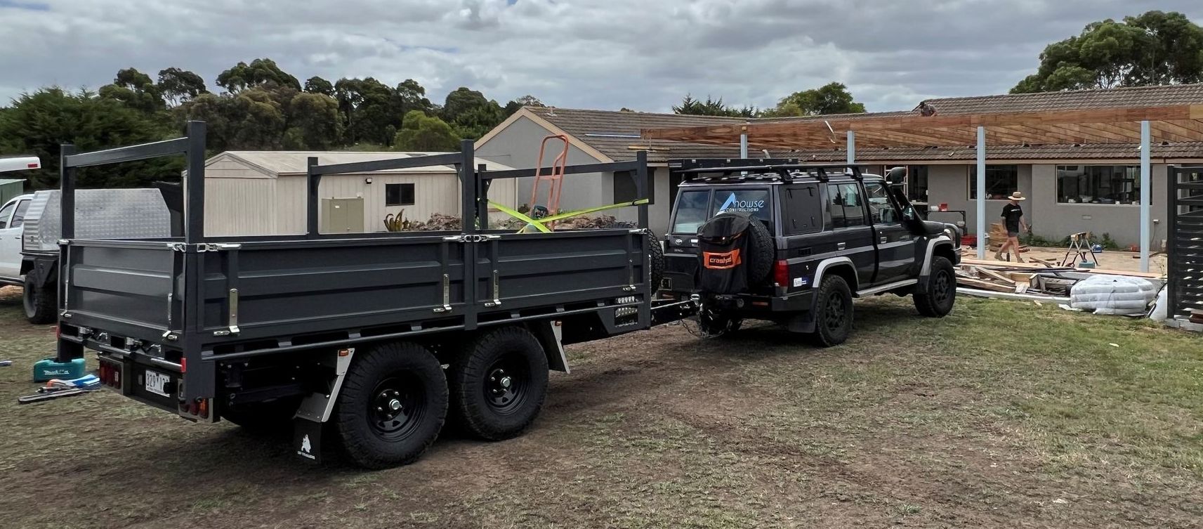 The tipper trailer of Howse Constructions at an active construction site and being towed by the businesses land cruiser.