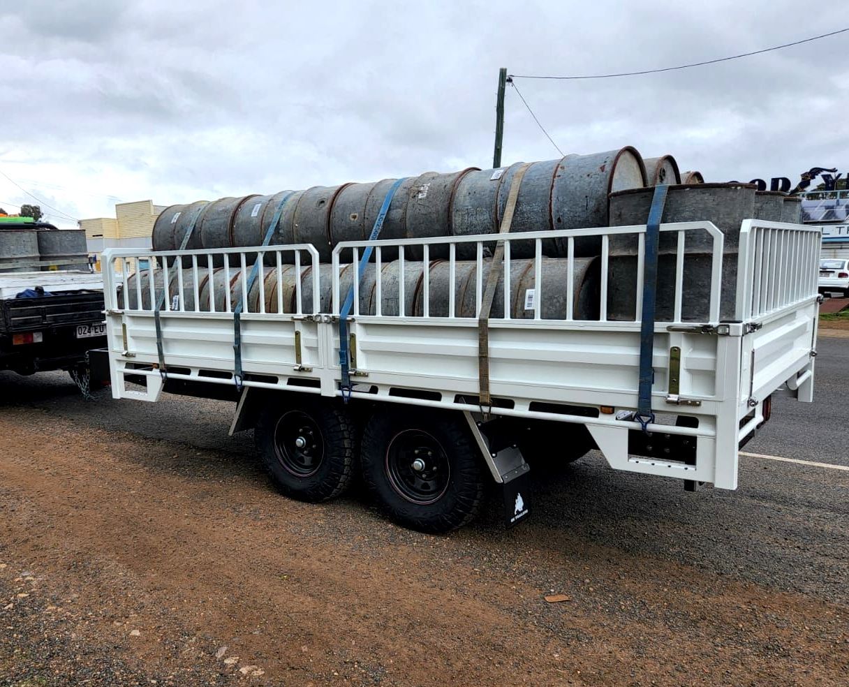 5.4m by 2.4m Flat Top Trailer with High-Volume Extender Dropsides loaded with Steel Drums.