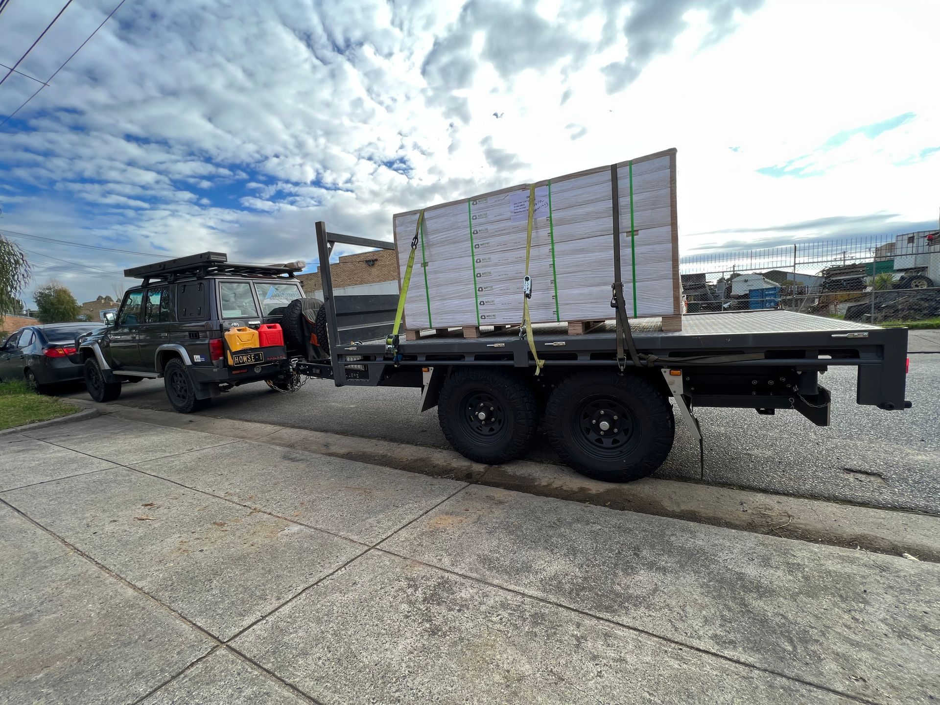 A tipper trailer with no dropides hauling supplies for Howse Constructions.