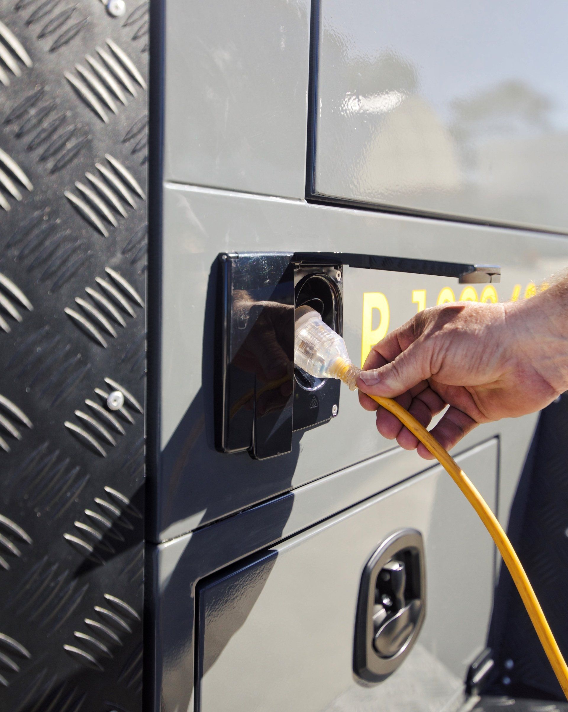 The integrated power system within the Builders trailer, a standard power cord is being plugged into the trailer for power.