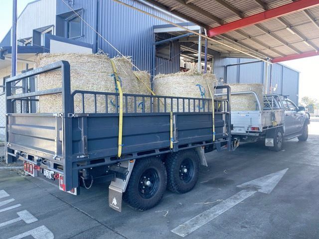 Rear Tipper Trailer with hay bales, hi-volume extender dropsides, tandem axles, and Maxxis Razr All Terrain Tyres.