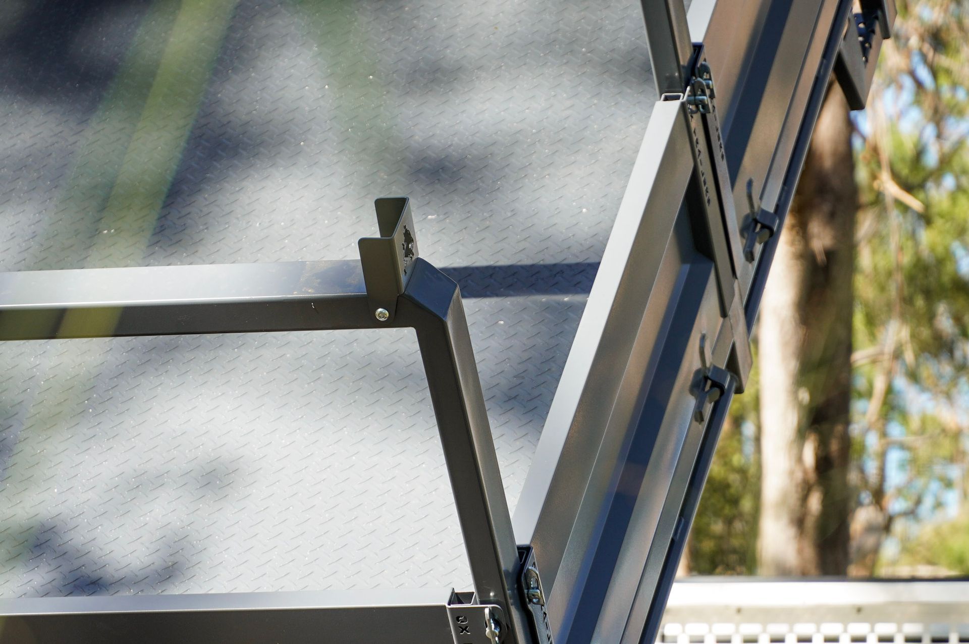 heavy duty custom flat top trailer for gee building at rural construction site with toolbox and canopy doors open.