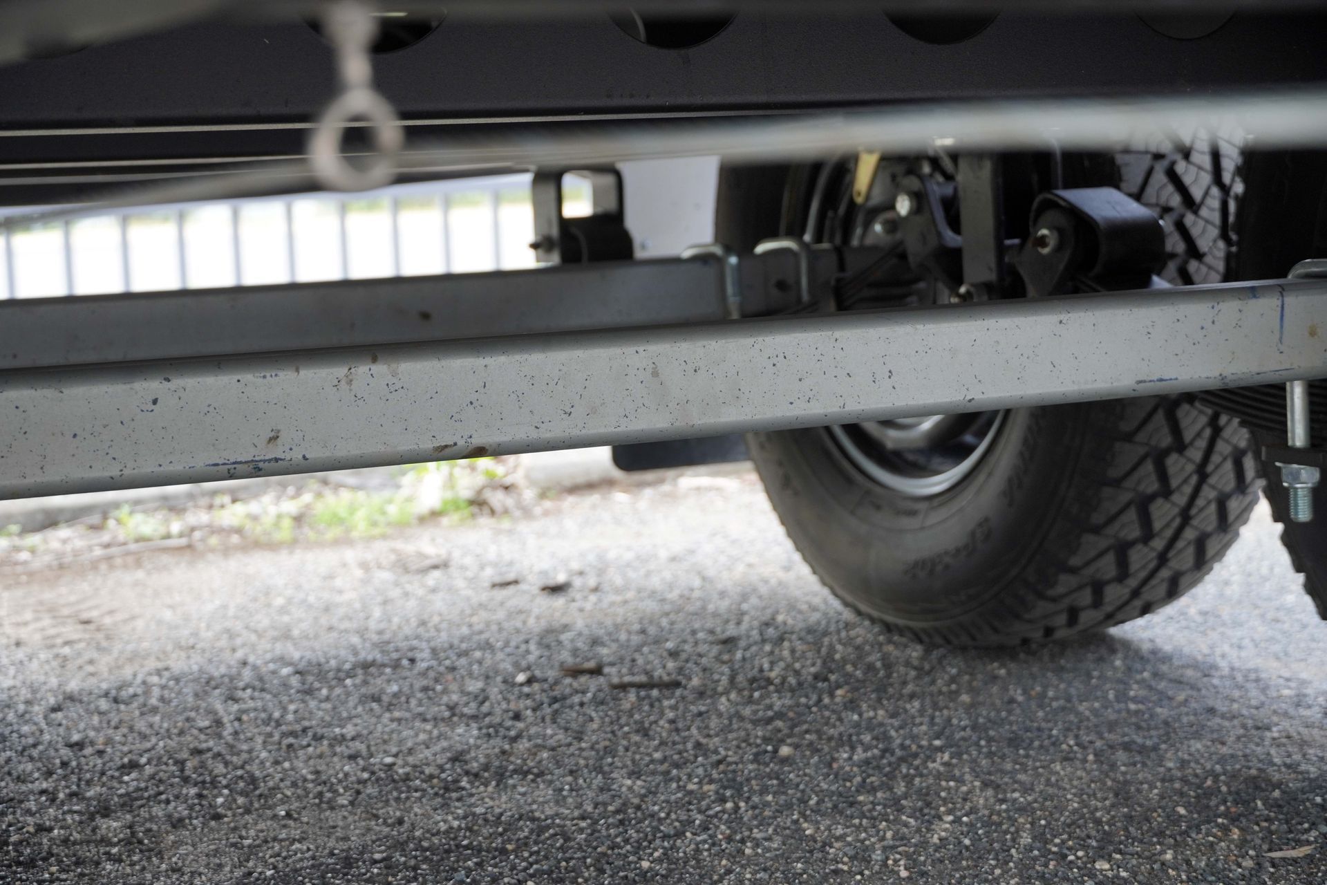 A close up of the tandem axles set-up under the trailer tray.