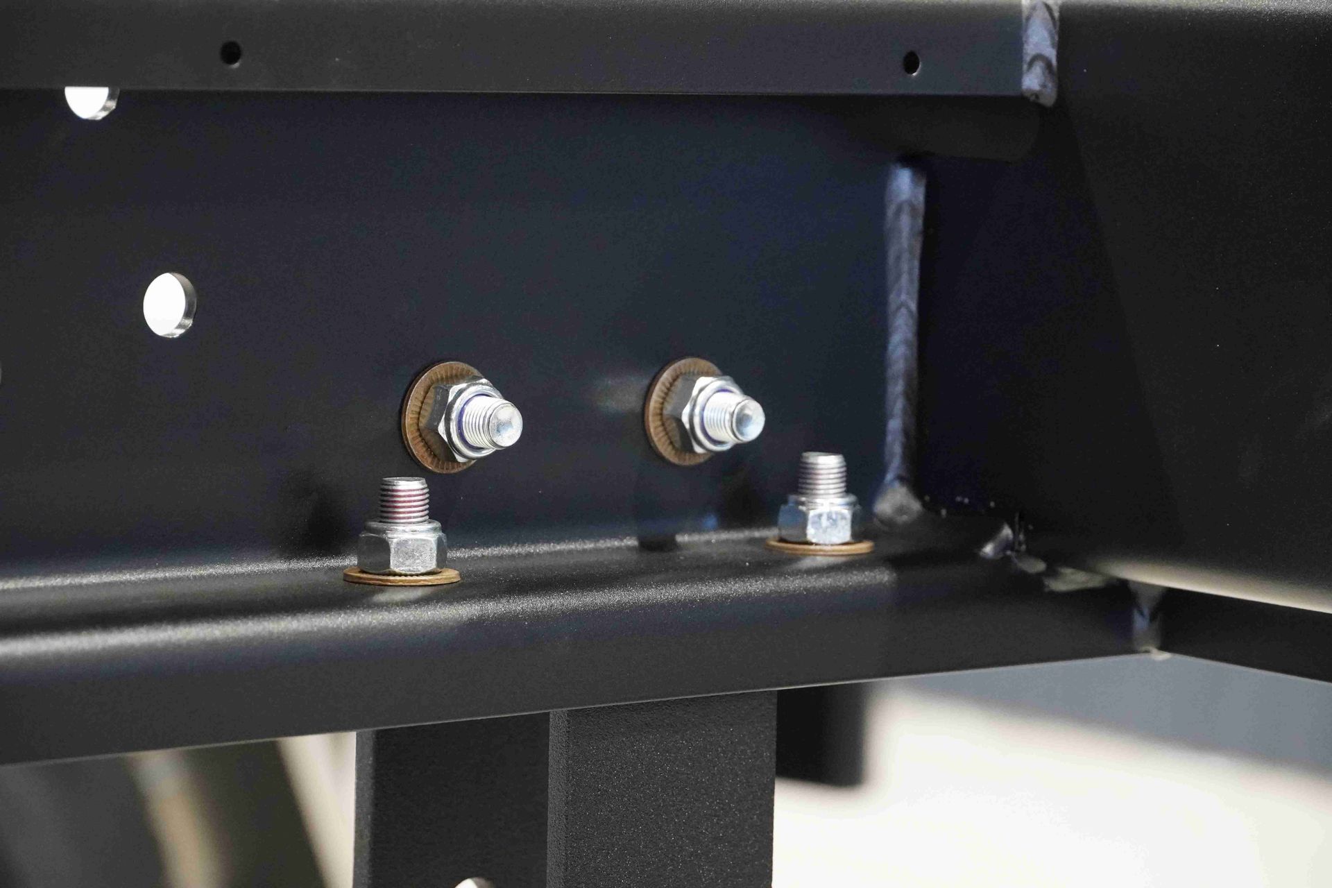 Heavy duty structural fasteners securing the tray to the chassis of a flat top trailer.