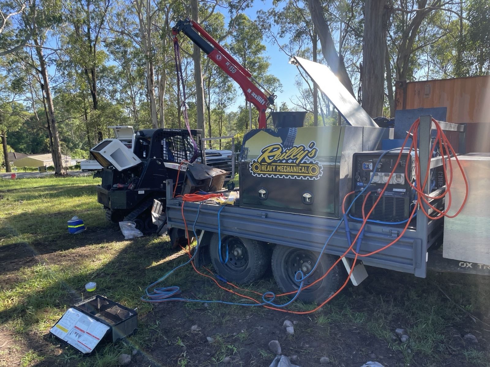 3.5t heavy duty diesel mechanics trailer with toolboxes and a crane by ox trailers, on site with a skid steer.