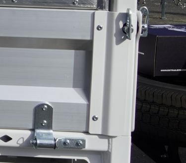 The bolted hinges and anti-buce latches of an ox trailer trade series flat top trailer.