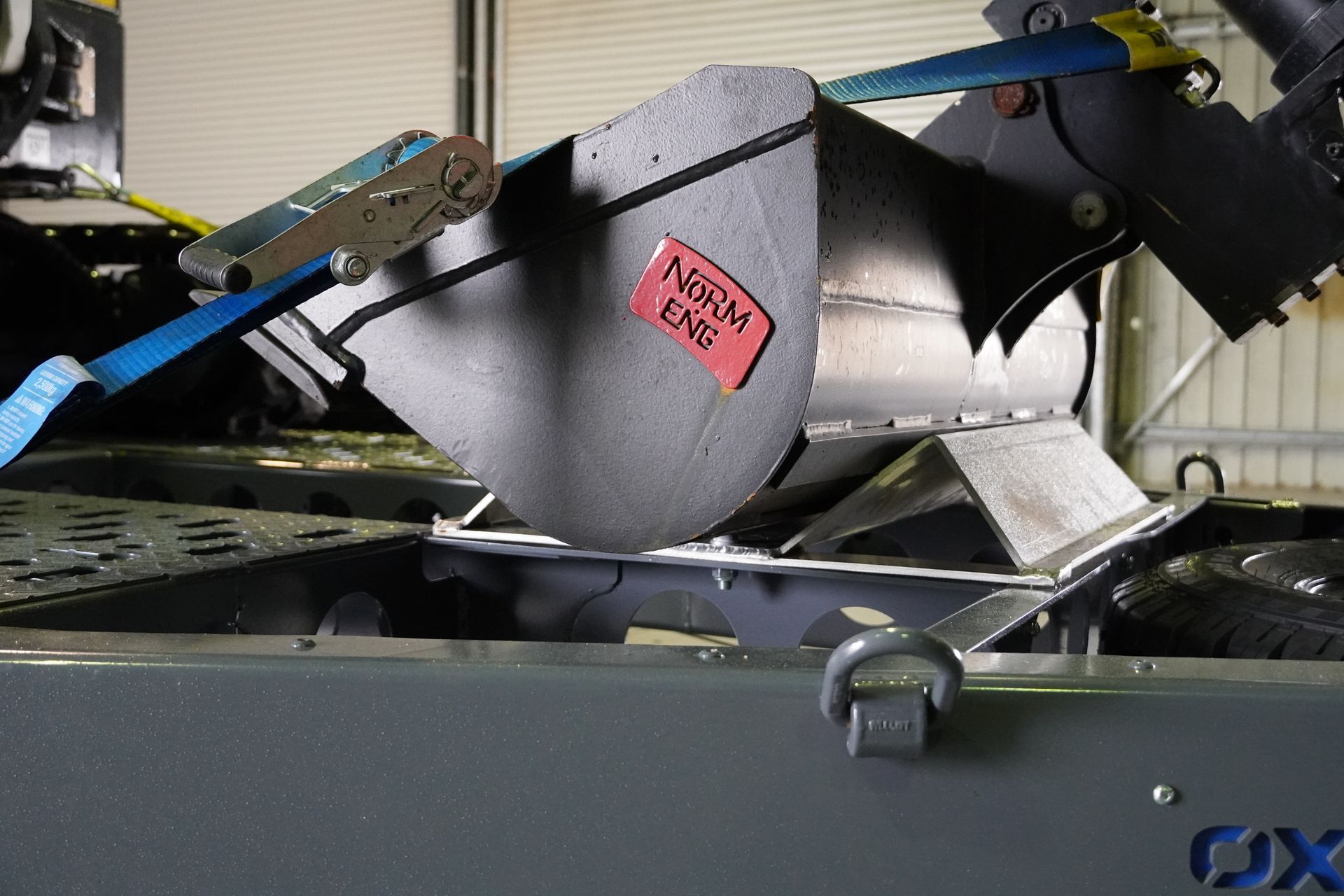 an excavator bucket in the bucket rest of an ox plant trailer.