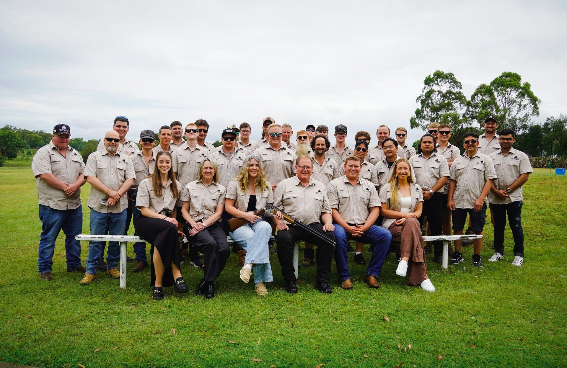 Group photo of the Ox Trailers team in Queensland, showcasing skilled Australian manufacturers and staff in workwear, standing outdoors under a sunny sky.