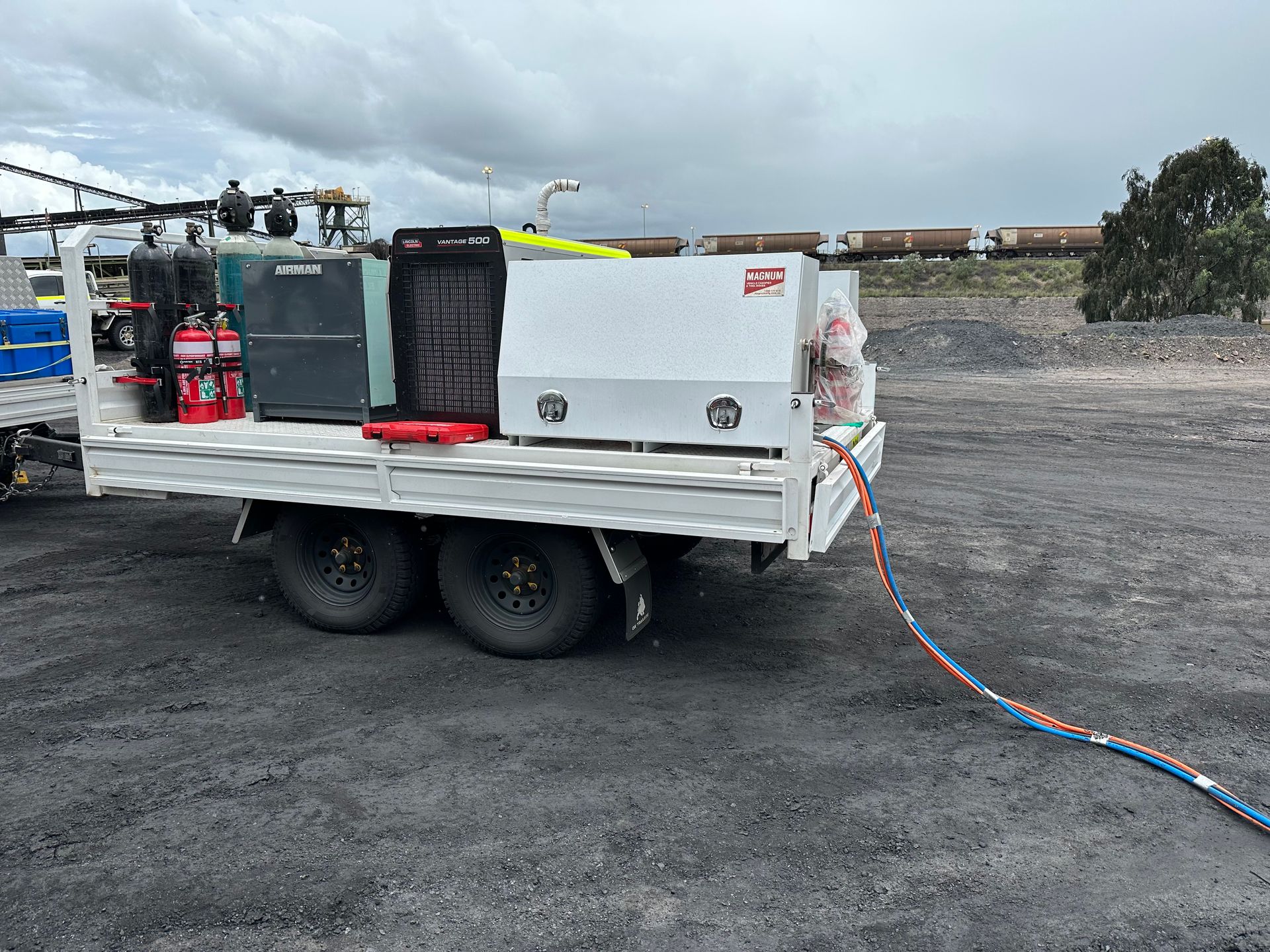 Flat Top Trailer with drop sides down servicing mining equipment.