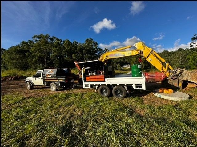 Harlock's Flat Top Trailer on site with large excavtor.