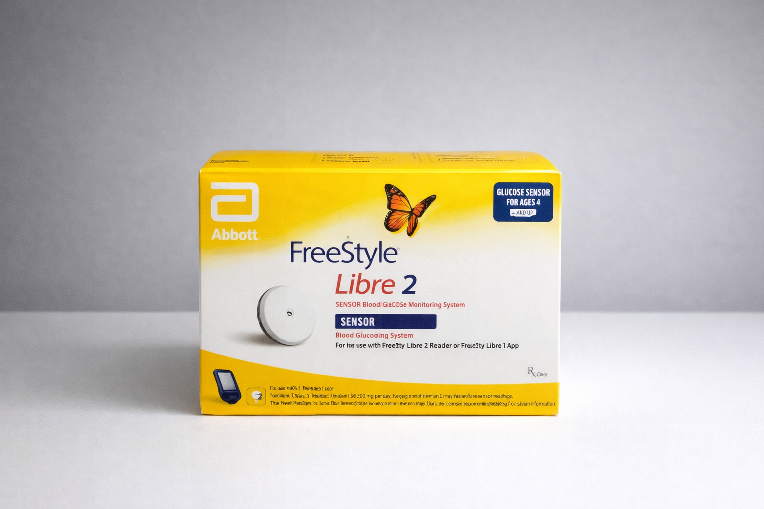 Yellow box of Freestyle Libre 2 sensor with a butterfly and a smartphone icon on a white surface.