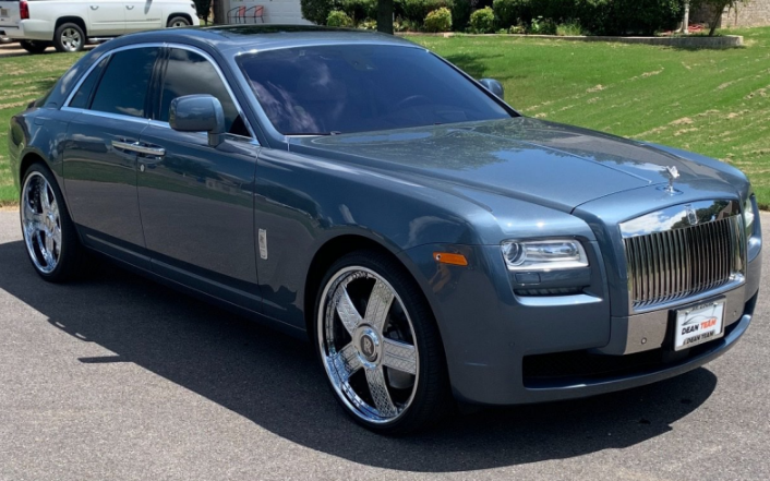 Gray Rolls-Royce sedan parked on a sunny street, front angled view
