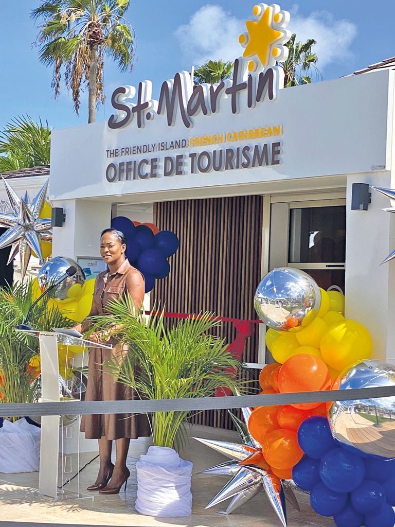 A woman is standing in front of a building decorated with balloons.