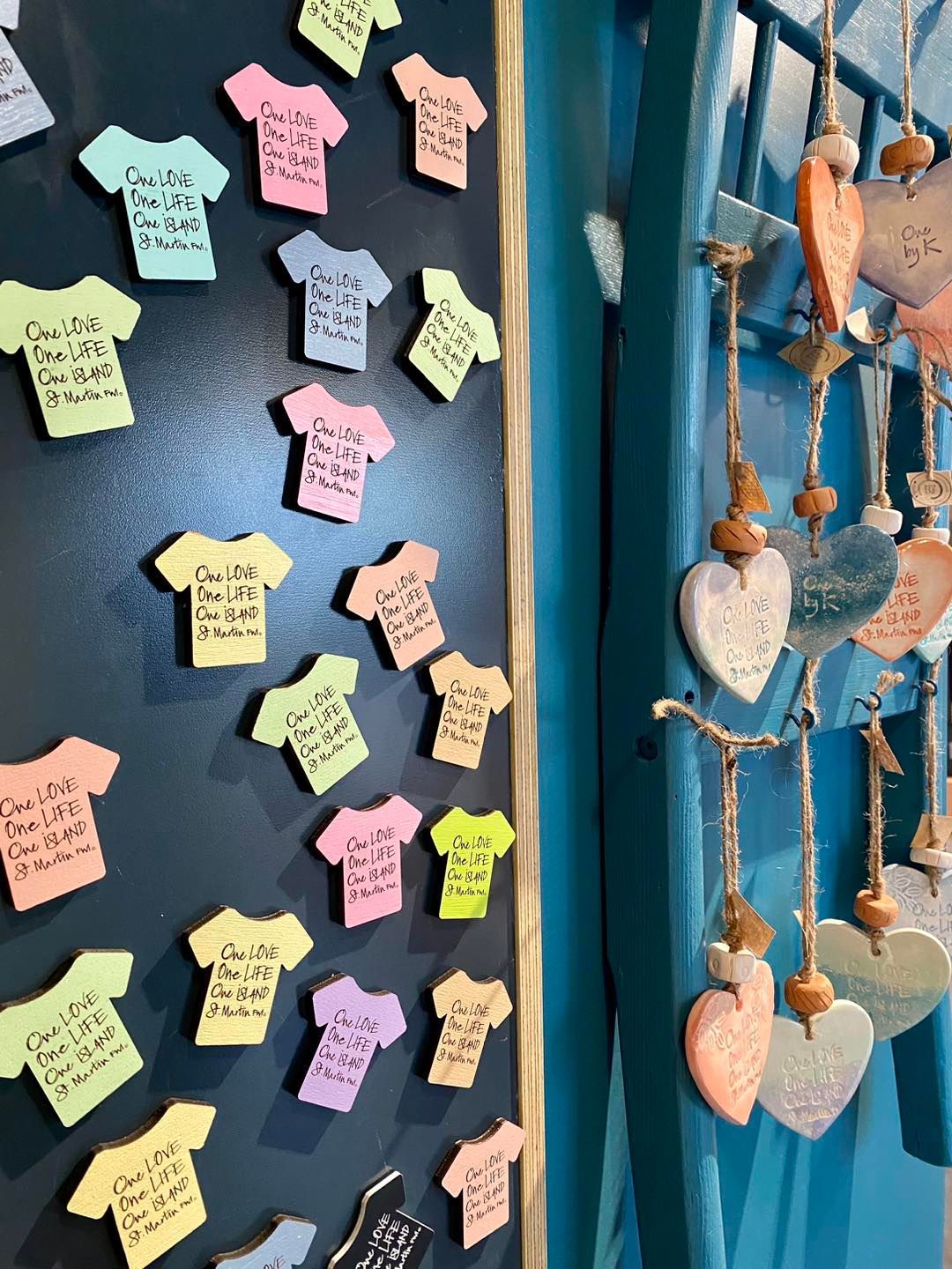 A blackboard with sticky notes on it in the shape of shirts and hearts.