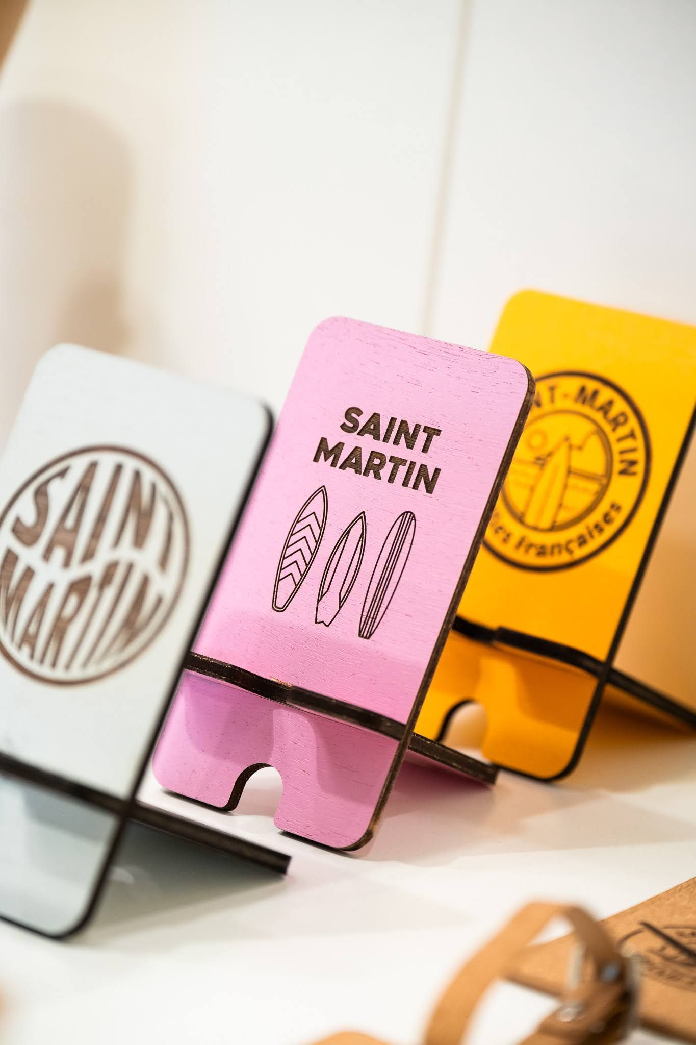 Trois supports de téléphone portable avec saint martin écrit dessus sont assis sur une table.