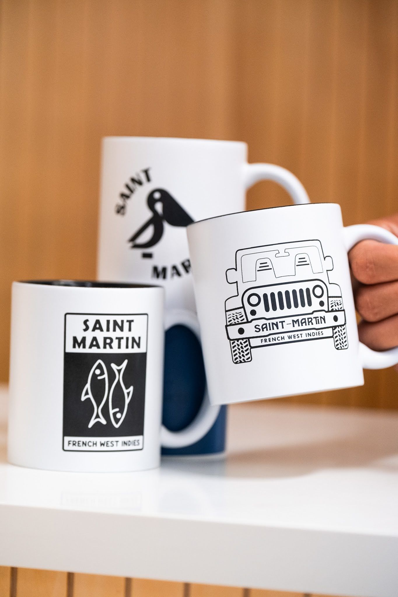 Une personne tient une tasse sur laquelle est écrit saint martin